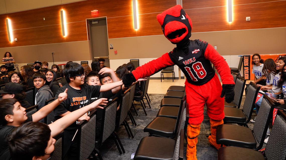 Red The Cardinal greeting a group of young student guests at Veteran's Day Ceremony